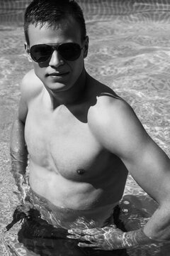 Summer Man Body Sun Skin Care. Beautiful Model With Sexy Body In Swimwear Tanning, 