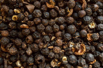 Fullscreen macro closeup with shallow depth of field of unmilled black peppercorns