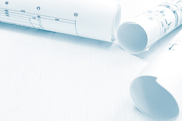 technical drawings and project plans, blueprint rolls on architect workplace desk 