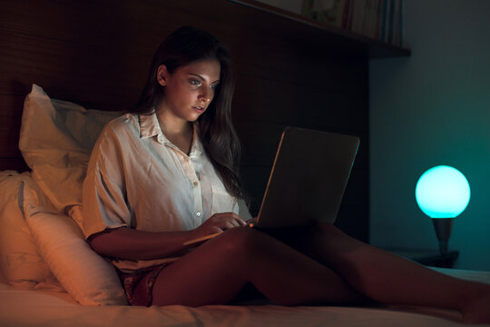Woman at night working on laptop