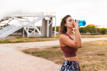 fitness woman drinking water from the bottle, closed eyes