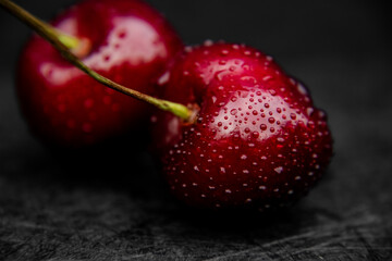 Close up of fresh, healthy and wet sweet cherry berry with water drops on it.