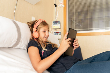 Little patient in hospital bed using a tablet. Medical concept