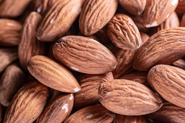 Closeup of shiny peeled almond seeds. Peeled almond texture. Superfood. Natural food.