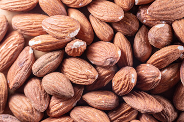 Closeup of shiny peeled almond seeds. Peeled almond texture. Superfood. Natural food.