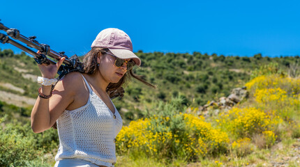girl with a professional tripod of photography and video walks on the mountain in summer © JuanFrancisco