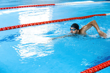 Sports male swimmer swimming in the pool, swimming crawl . Side view, techniques swimming, soft...