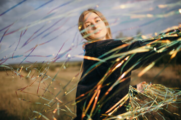 Peaceful woman with shiny confetti on meadow