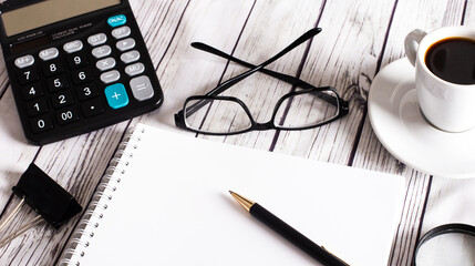 Workplace with notepad, calculator, glasses, coffee and pen. Business concept