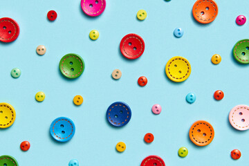Sewing colorful buttons background on blue.