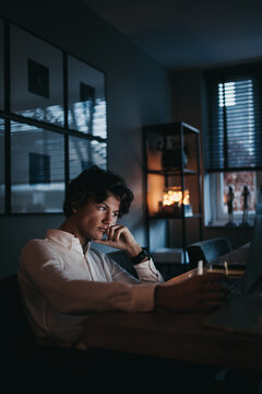 Serious teen boy staring at his laptop screen trying to study for school
