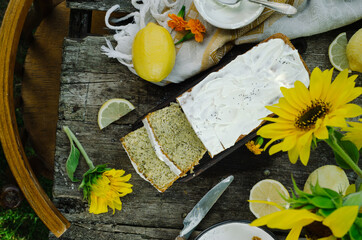 Homemade lemon cake with poppy seeds and cream cheese glaze. Summer cake on a wooden table in rustic style.