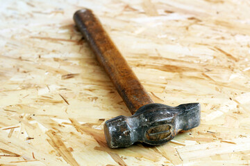 Old hammer on wooden background