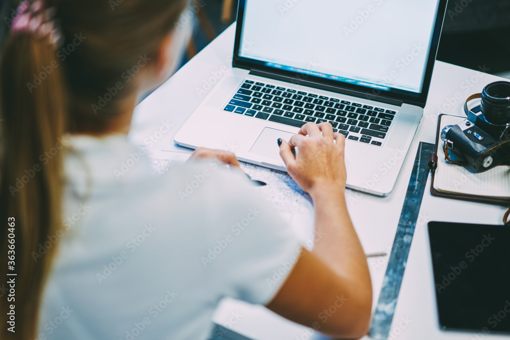 Poster cropped back view of female graphic designer searching information on internet website on modern lap
