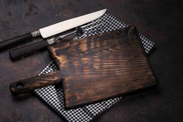 Old kitchen utensils. Fork, knife, cutting board and napkin. View from above