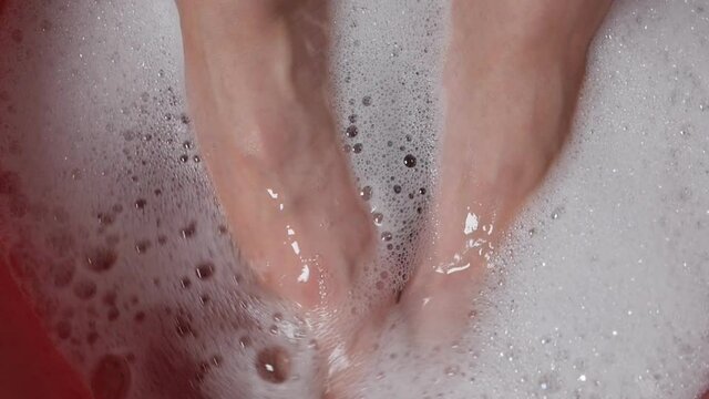 Women soak their fingers in the bath, foam to relax and get ready to cut their nails