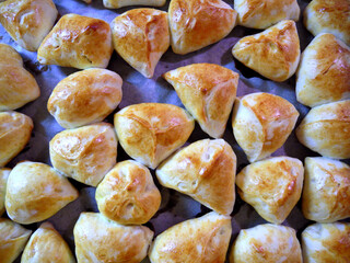 Baked pies with apples on a baking sheet. Homemade delicious pastries.