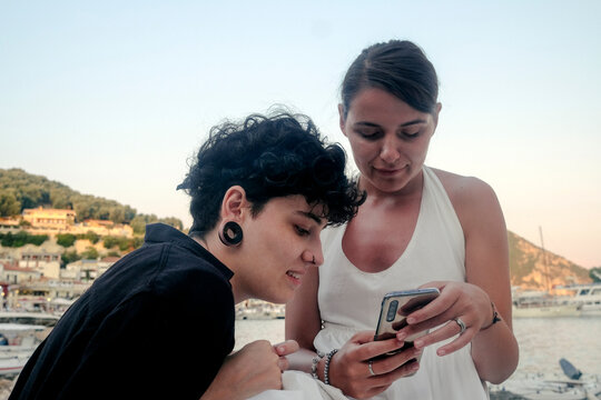 Two female models looking at the photo on a mobile phone