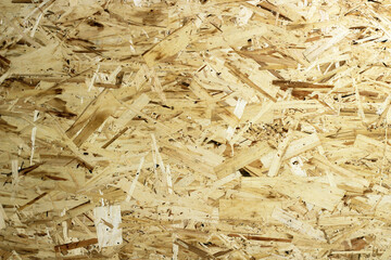 Oriented Strand Board. Chipboard building material. OSB wooden panel made of pressed sandy brown wood shavings as background closeup