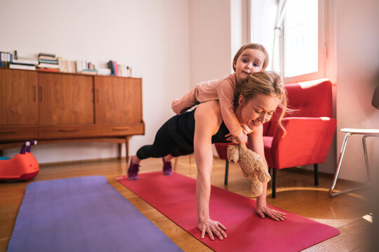 Mother and little daughter exercising at home