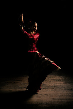 Young woman dancing flamenco on black