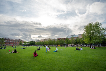 People relax on grass at summer  in artificial island New Holland in St. Petersburg