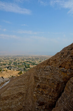 View of city of Jericho from the mountains of temptation. Ancient and hot city at the foot of the mountains, vertical photo.