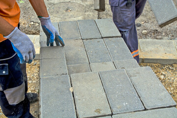 Laying concrete bricks for the sidewalk