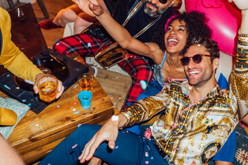 Happy friends enjoying with confetti in party at home