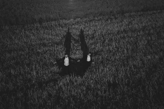 Lovely couple holding hands in field.