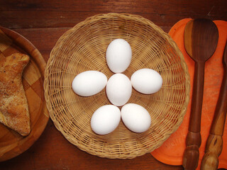 Huevos blancos en una canasta simulando una figura humana