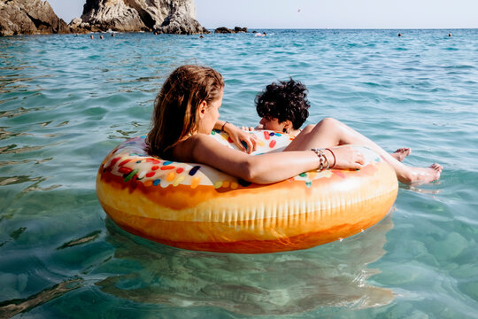 Friends enjoying in the sea in donut float