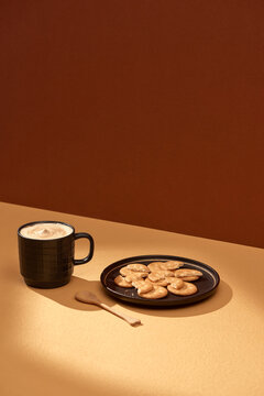 Cup of coffee and plate with chocolate cookies