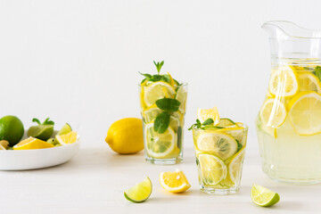 Summer refreshing drink of lemon, lime and mint, jug with lemonade and glasses and citrus slices