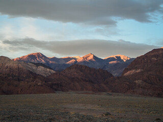 Death Valley. The tops of the mountains are lit by the last rays of the setting sun.