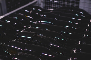 Wine cellar with wine black bottle, basement of winery and brewery, containers with alcohol bottles...
