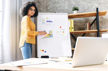 Confident young african-american woman conducts webinar, business training online. Online coach...