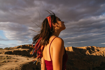 Woman closed eyes and cliff background