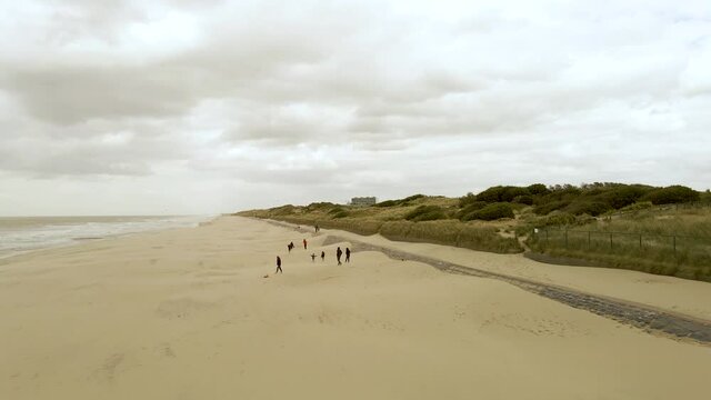 View of the dunes and the beach with a group of people