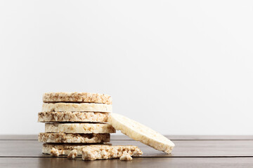 Rice and buckwheat cakes on a wood table, white background.
