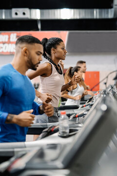 People running in machine treadmill at fitness gym.