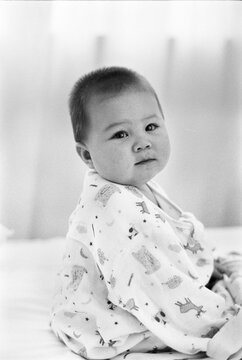 Chubby Mixed Race Asian Caucasian Boy Sitting In Bed.