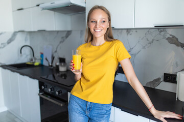 Portrait of a woman drinking juice in her kitchen
