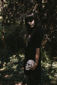 Elegant woman in Halloween black dress with sugar skull makeup