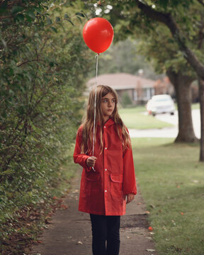 Lonely Child Holding Red Balloon Outside