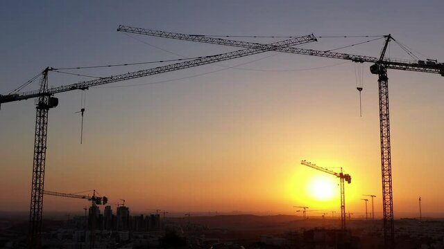 Construction Site and Cranes silhouette, In modiin City,Israel,Aerial view, 
Drone view,July, Sunset,2020
