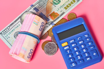 Banknote of one hundred dollars and ukrainian money near calculator on pink background