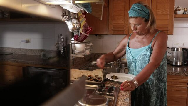 Video in 4k di  signora anziana vestita casual che prepara l'antipasto di cozze per il pranzo