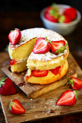 Selective focus. Strawberry Cake Sponge cake with fresh strawberries and cream. Victoria sponge cake on a dark background.