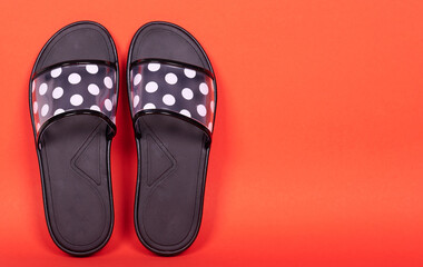 Rubber flip flop with dot pattern. Isolated on red background. Copy space.